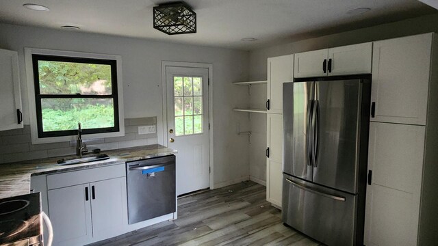 4030 Old Rte 22, Brewster, NY 10509 - kitchen featuring appliances with stainless steel finishes, white cabinetry, open shelves, decorative backsplash, and light wood-style flooring
