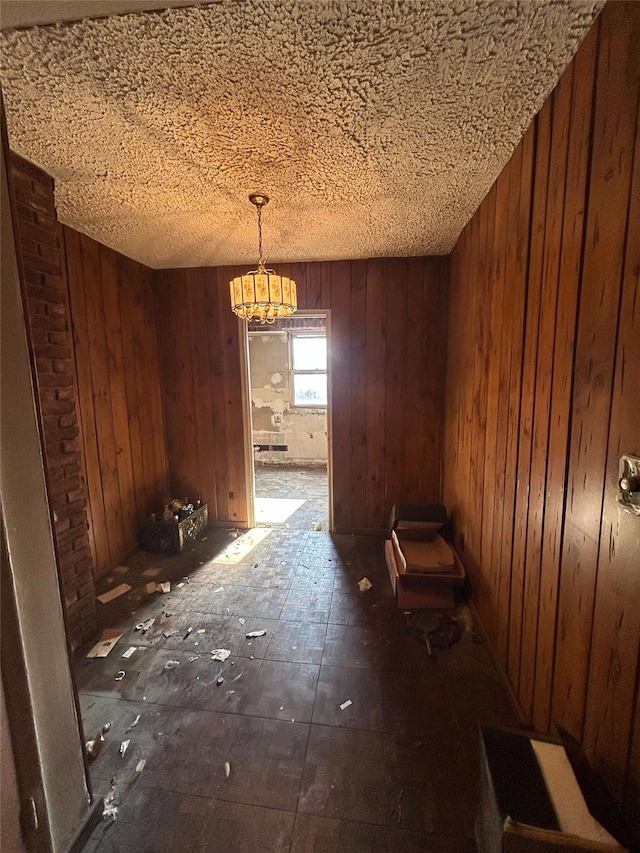 unfurnished dining area featuring wood walls