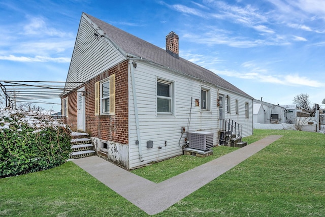 view of front facade with a front yard and central air condition unit