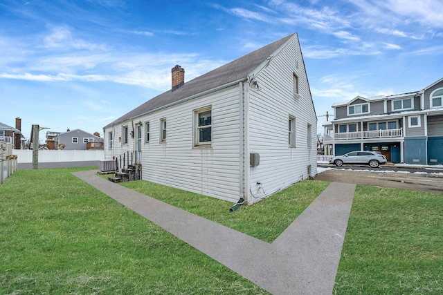 view of side of home featuring central AC unit and a lawn