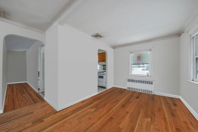 spare room featuring radiator and hardwood / wood-style floors