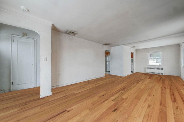 unfurnished room with radiator and light hardwood / wood-style flooring