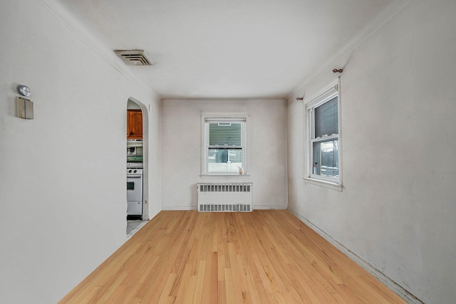 unfurnished room featuring light hardwood / wood-style flooring and radiator heating unit