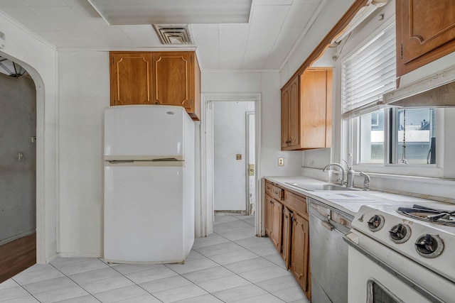 kitchen with light tile patterned flooring, sink, dishwashing machine, white fridge, and gas stove