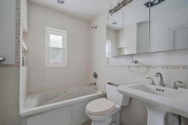 full bathroom featuring tasteful backsplash, sink, tile walls, bathtub / shower combination, and toilet