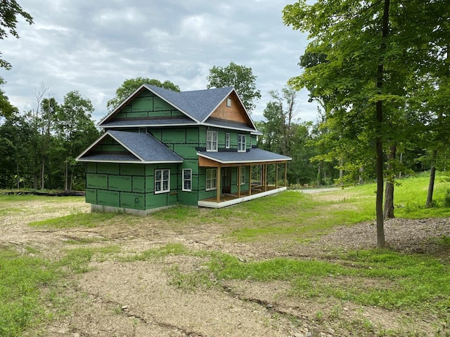 rear view of property with a porch and a yard