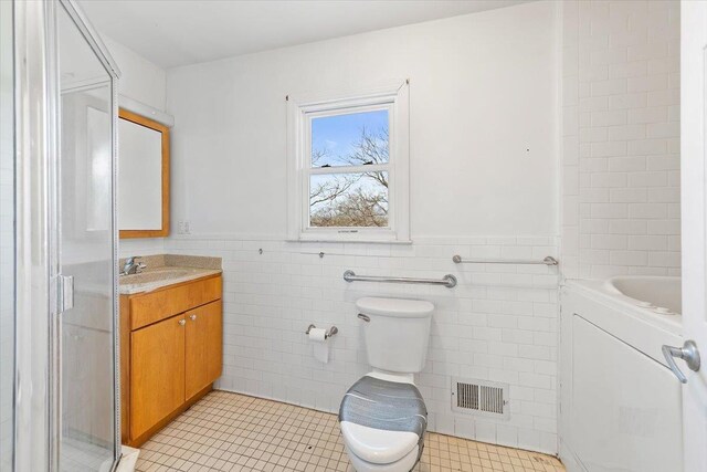 313 Sixth Ave, Pelham, NY 10803 - bathroom with tile patterned floors, vanity, washer / dryer, and tile walls
