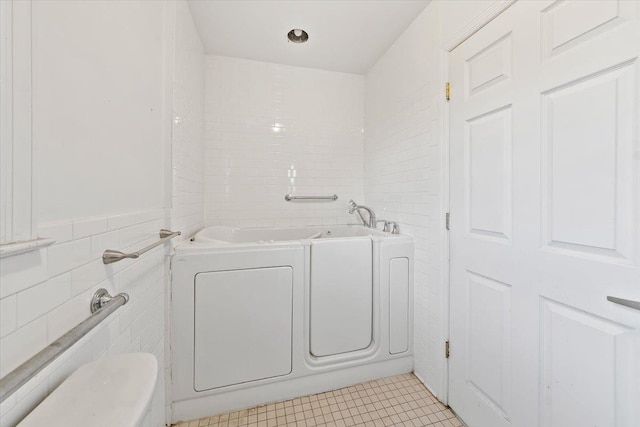 313 Sixth Ave, Pelham, NY 10803 - bathroom featuring tile walls, tile patterned flooring, and a washtub