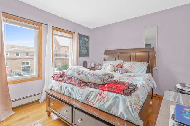 11122 114th St, South Ozone Park, NY 11420 - bedroom with a baseboard radiator and light wood-type flooring