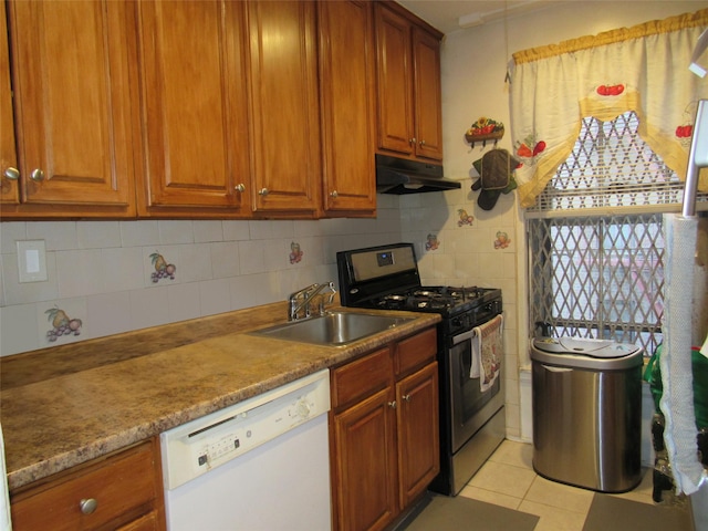 kitchen featuring light tile patterned floors, stainless steel gas range, white dishwasher, under cabinet range hood, and a sink