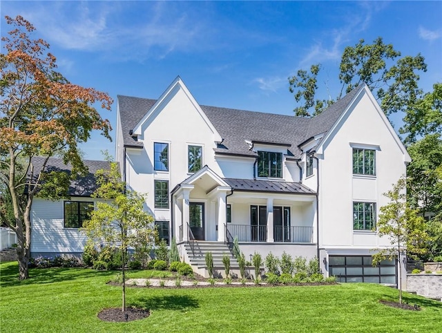 modern inspired farmhouse featuring metal roof, a front lawn, a standing seam roof, and roof with shingles