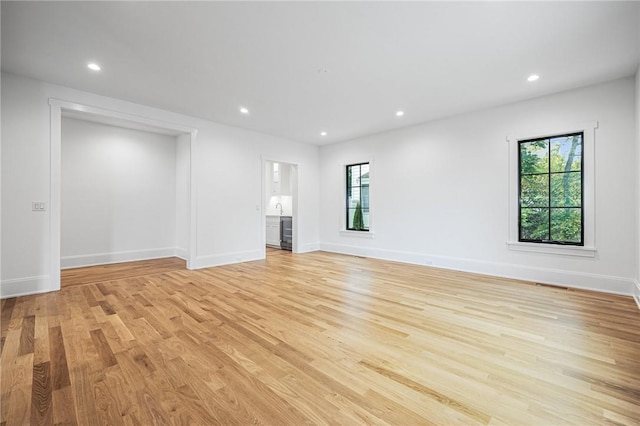 unfurnished living room featuring recessed lighting, baseboards, and light wood finished floors