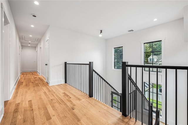 hallway with recessed lighting, visible vents, attic access, light wood-style floors, and an upstairs landing