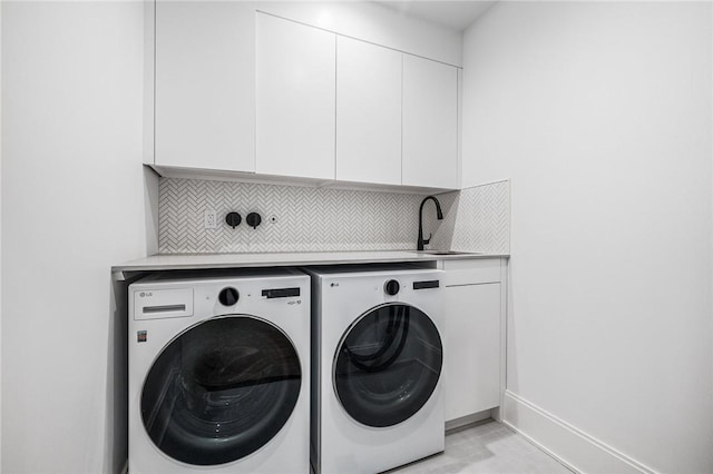 laundry room with washer and dryer, cabinet space, a sink, and baseboards