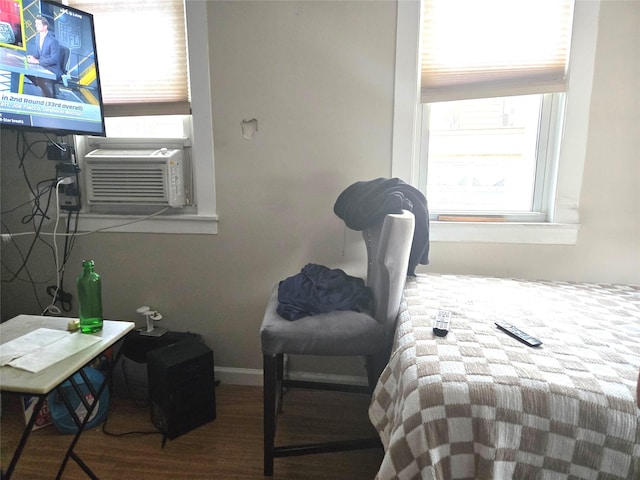 bedroom featuring baseboards, wood finished floors, and cooling unit