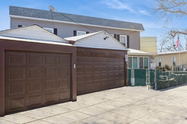31-25 45th St, Astoria, NY 11103 - view of front of property featuring a shingled roof, fence, an attached garage, and driveway