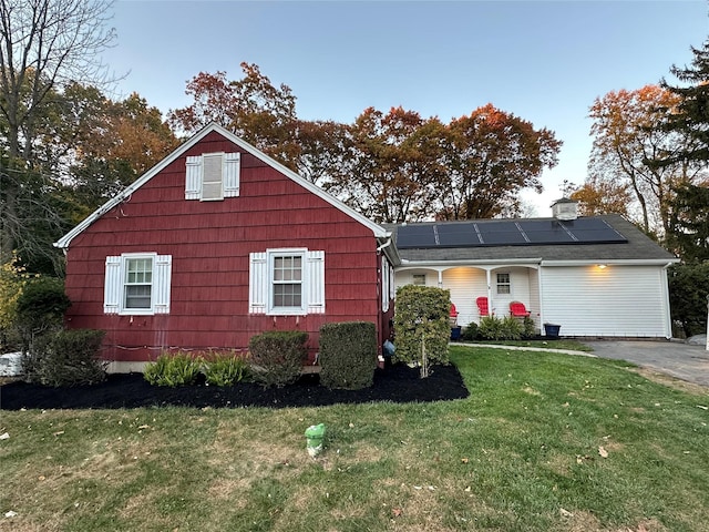 view of front of house with a front lawn and solar panels