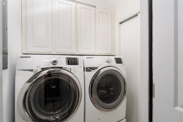 washroom featuring washing machine and dryer and cabinets