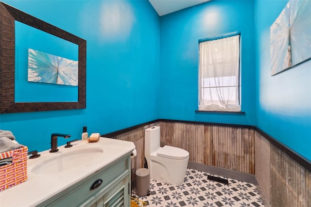 bathroom featuring a wainscoted wall, vanity, and toilet