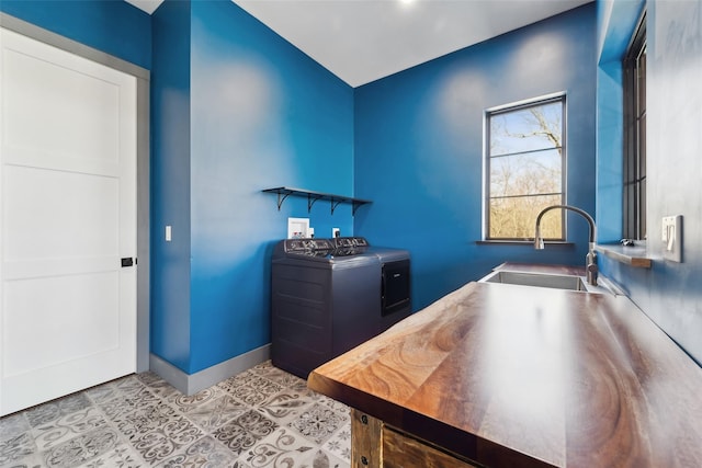 office featuring independent washer and dryer, baseboards, a sink, and tile patterned flooring