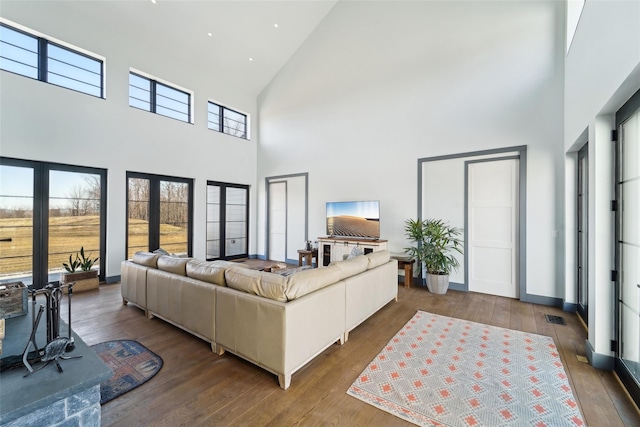 living area with baseboards, visible vents, french doors, and hardwood / wood-style flooring