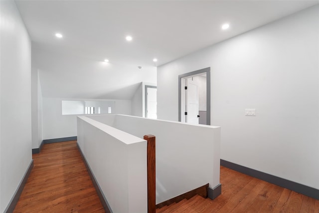 hall featuring baseboards, an upstairs landing, recessed lighting, and hardwood / wood-style floors
