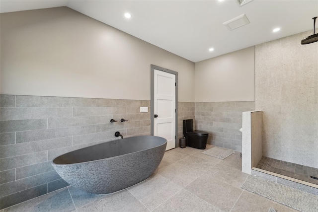 bathroom featuring a soaking tub, a tile shower, recessed lighting, and tile walls