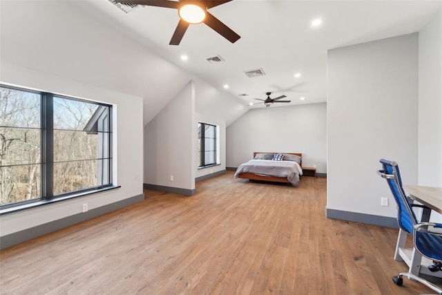 bedroom with light wood finished floors, baseboards, visible vents, and vaulted ceiling