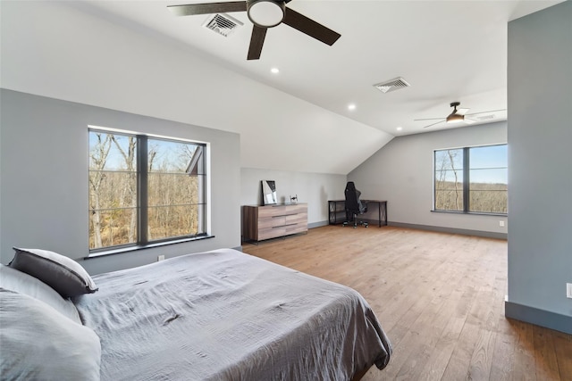 bedroom featuring baseboards, lofted ceiling, visible vents, and wood finished floors