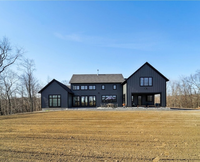 back of house featuring a lawn and board and batten siding