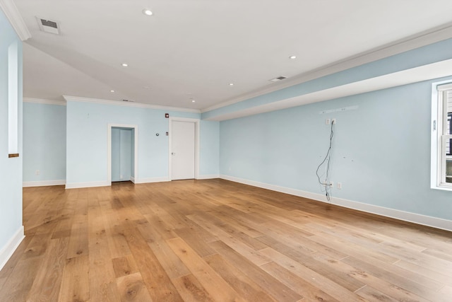 spare room with crown molding and light wood-type flooring