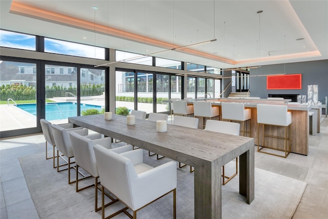 dining space with plenty of natural light and a raised ceiling