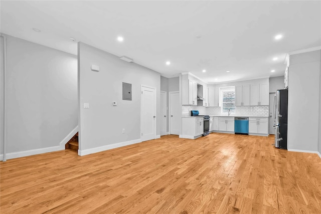 kitchen featuring wall chimney exhaust hood, white cabinetry, stainless steel appliances, light hardwood / wood-style floors, and backsplash