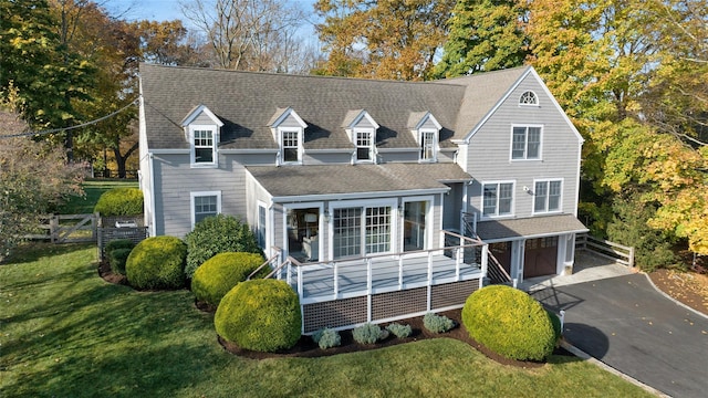 view of front of property featuring aphalt driveway, an attached garage, fence, roof with shingles, and a front lawn