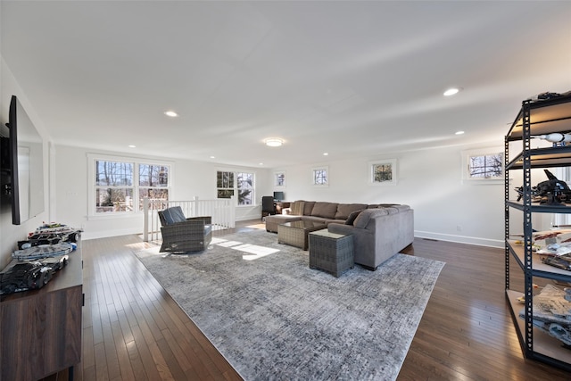 living area featuring plenty of natural light, baseboards, dark wood-type flooring, and recessed lighting