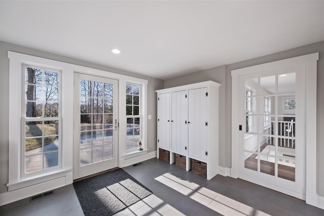 doorway to outside with recessed lighting, visible vents, baseboards, and dark tile patterned flooring