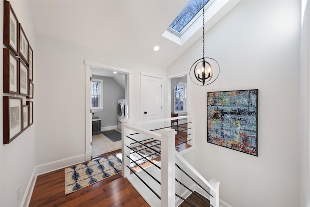 foyer entrance featuring recessed lighting, separate washer and dryer, wood finished floors, baseboards, and lofted ceiling with skylight