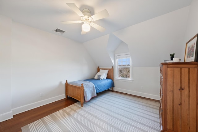 bedroom featuring light wood-style floors, visible vents, vaulted ceiling, and baseboards