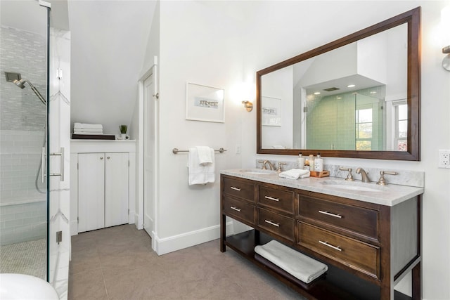 full bathroom featuring double vanity, a shower stall, baseboards, and a sink