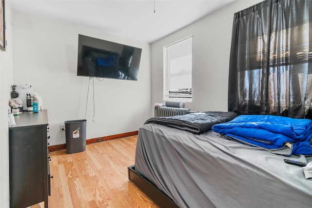 bedroom featuring hardwood / wood-style flooring and radiator