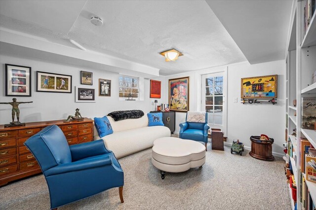 living area with a textured ceiling and baseboards