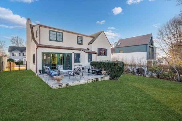 back of house with a yard, a patio, a chimney, and fence