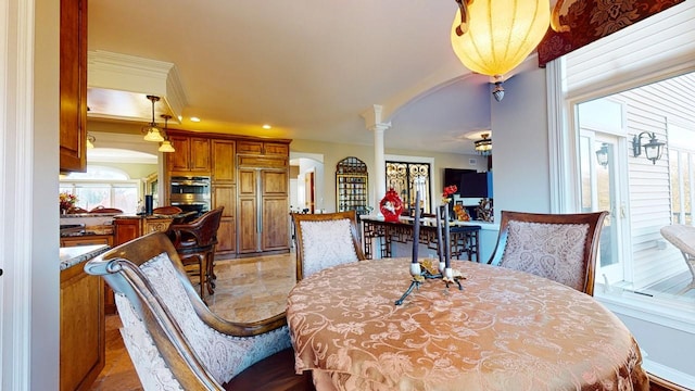 dining space with crown molding, decorative columns, recessed lighting, and arched walkways