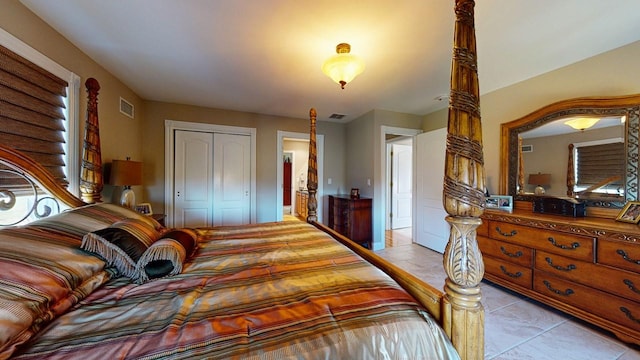 bedroom featuring tile patterned flooring, visible vents, and a closet