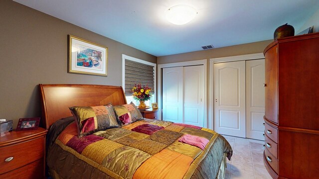 bedroom featuring visible vents and multiple closets