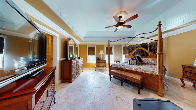 bedroom with baseboards, a raised ceiling, stone tile floors, and crown molding