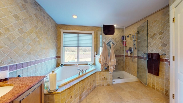 bathroom with vanity, a stall shower, tile walls, a bath, and tile patterned floors