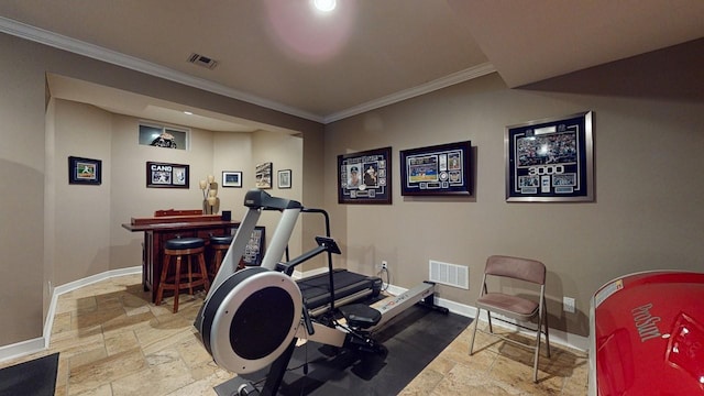 exercise room with visible vents, crown molding, baseboards, a dry bar, and stone tile floors