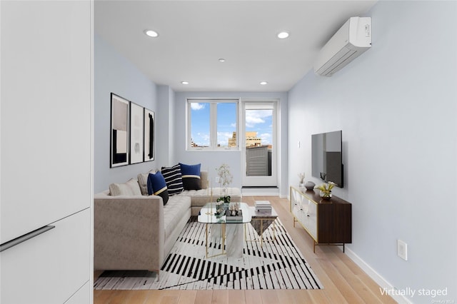 living room featuring a wall mounted air conditioner and light hardwood / wood-style floors