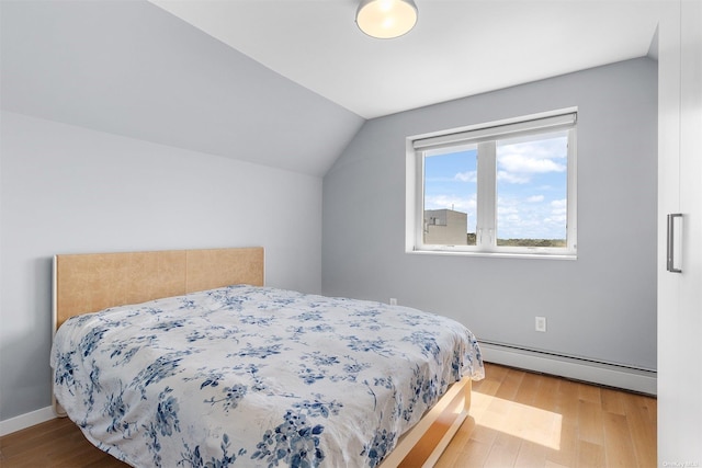 bedroom featuring baseboard heating, wood-type flooring, and vaulted ceiling